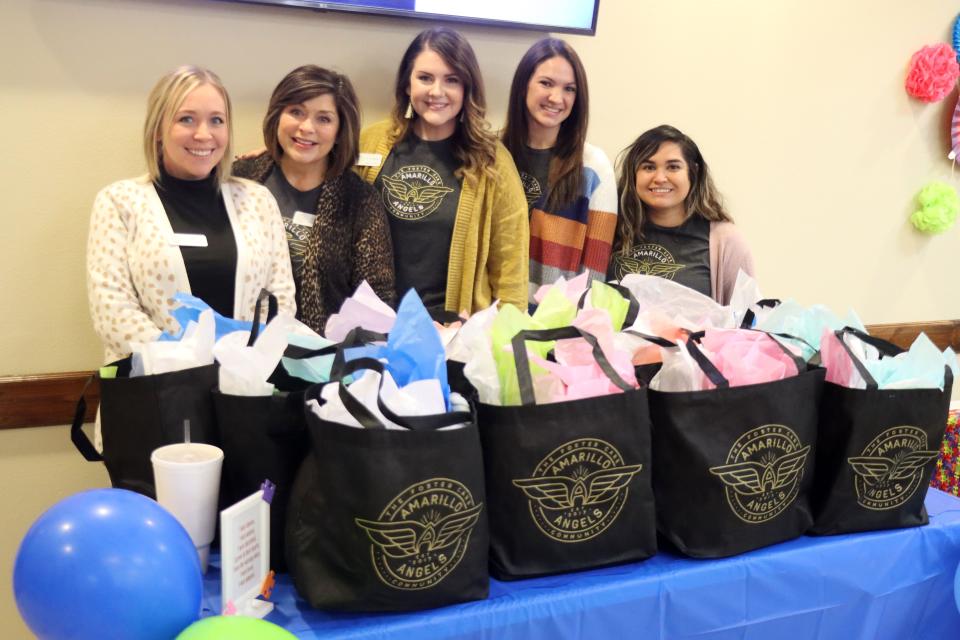 Kyndal Huffman, Gwen Hicks, Cali Kimberling, Cayenne Williams and Vanessa Marquez, representing Amarillo Angels, hand out gifts to those being adopted at the National Adoption Day event Nov. 18 at the Randall County Courthouse.