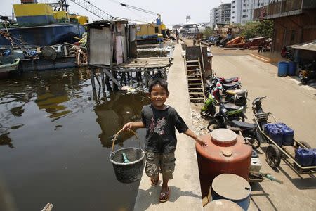 A child returns from using a latrine along the sea wall in Muara Baru, north Jakarta, September 30, 2014. REUTERS/Darren Whiteside