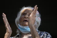 Zelia de Carvalho Morley, 106, gives thanks before receiving a shot of China's Sinovac CoronaVac vaccine for the new coronavirus at the retirement home where she lives in Rio de Janeiro, Brazil, Wednesday, Jan. 20, 2021. De Carvalho Morley lived through the 1918 flu pandemic. (AP Photo/Bruna Prado)