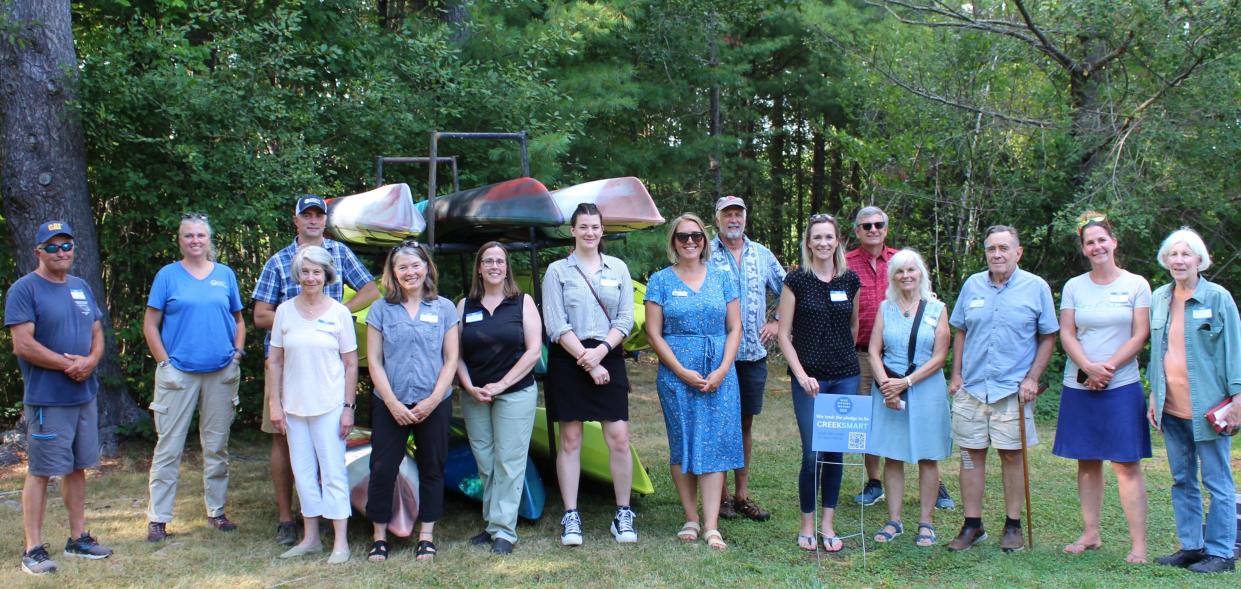 York River Stewardship Committee members and project partners stand next to kayaks purchased for upcoming programs.