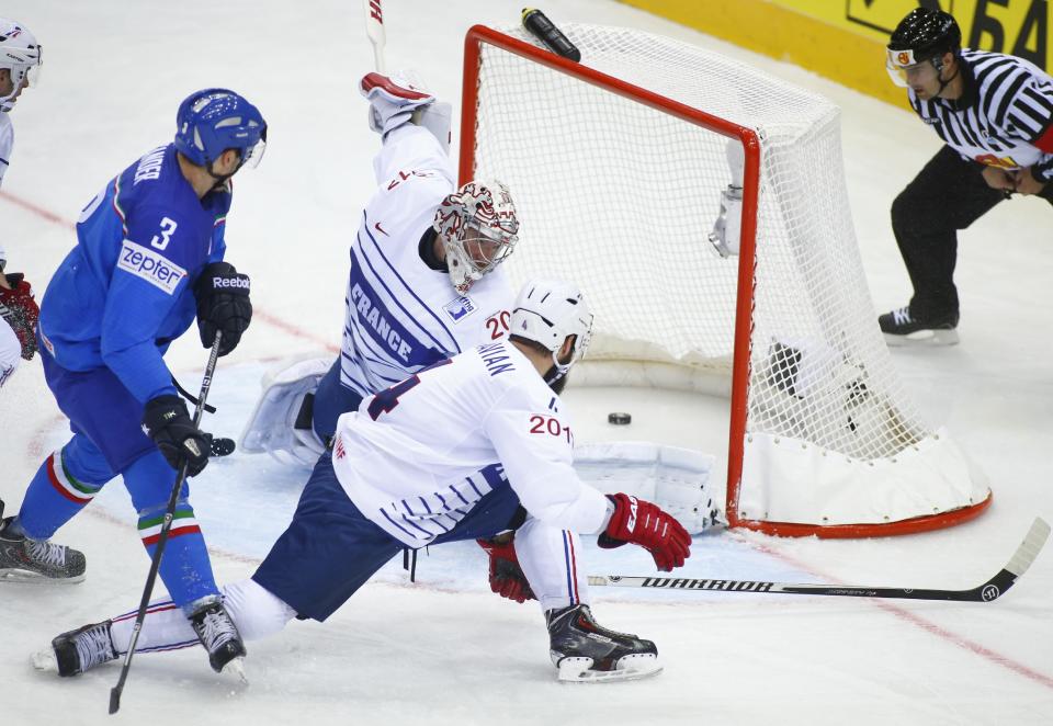 Italy's Markus Gander, left, scores past France's Cristobal Huet during the Group A preliminary round match between France and Italy at the Ice Hockey World Championship in Minsk, Belarus, Sunday, May 11, 2014. (AP Photo/Sergei Grits)