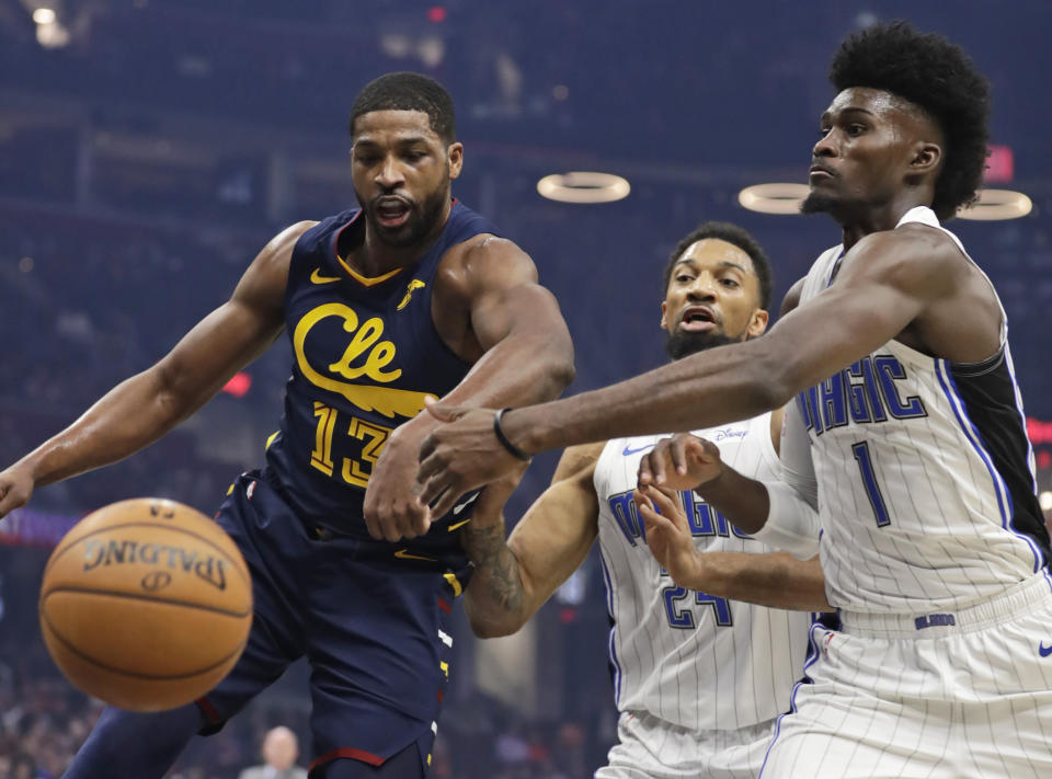 Orlando Magic's Jonathan Isaac (1) and Cleveland Cavaliers' Tristan Thompson (13) battle for the ball in the first half of an NBA basketball game, Friday, Dec. 6, 2019, in Cleveland. (AP Photo/Tony Dejak)