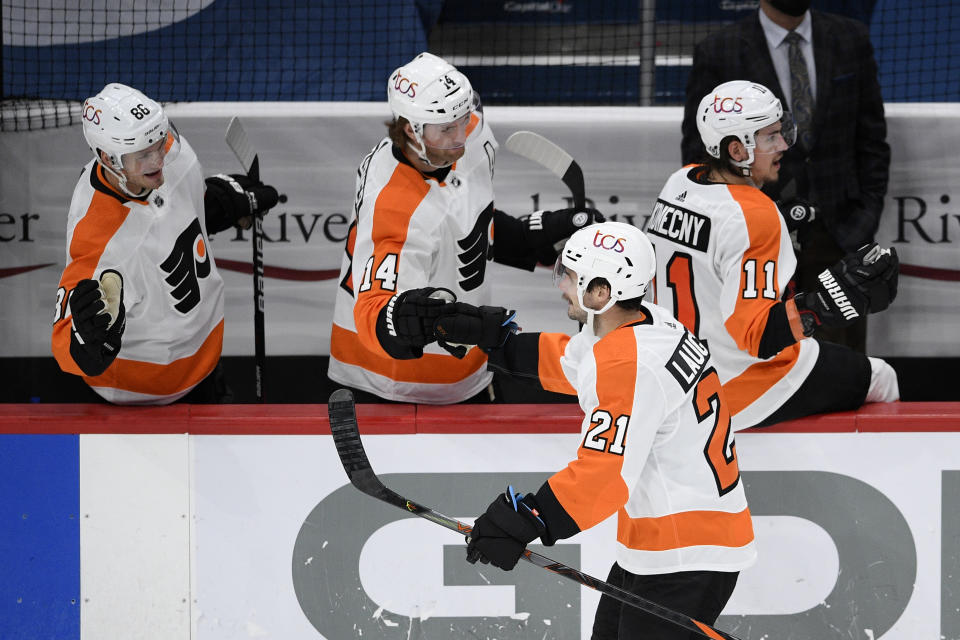 Philadelphia Flyers center Scott Laughton (21) celebrates his goal with the bench during the third period of the team's NHL hockey game against the Washington Capitals, Saturday, May 8, 2021, in Washington. The Capitals won 2-1 in overtime. (AP Photo/Nick Wass)