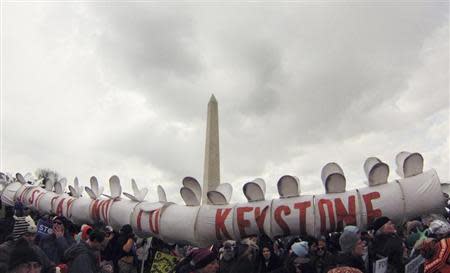 Demonstrators carry a replica of a pipeline during a march against the Keystone XL pipeline in Washington, February 17, 2013. The TransCanada Corp pipeline would link the oil sands of northern Alberta, the world's third largest crude resource, to refineries and ports in Texas. Environmentalists say approval of the pipeline will encourage more development in the oil sands, where extraction is carbon intensive, leading to greater greenhouse gas emissions. REUTERS/Richard Clement