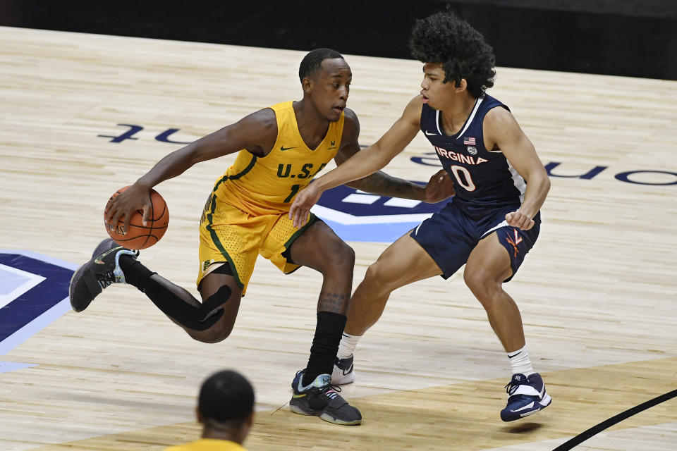 San Francisco's Jamaree Bouyea, left, is guarded by Virginia's Kihei Clark, right, in the second half of an NCAA college basketball game, Friday, Nov. 27, 2020, in Uncasville, Conn. (AP Photo/Jessica Hill)