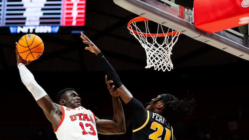 Utah Utes center Keba Keita (13) shoots the ball with Virginia Commonwealth Rams forward Christian Fermin (21) jumping up to defend during the NIT quarterfinal game between the Utah Utes and the Virginia Commonwealth Rams at the Jon M. Huntsman Center in Salt Lake City on Wednesday, March 27, 2024.