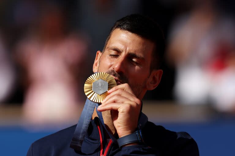 Djokovic besando la medalla dorada que buscó desde Pekín 2008 y que recién pudo ganar en París 2024