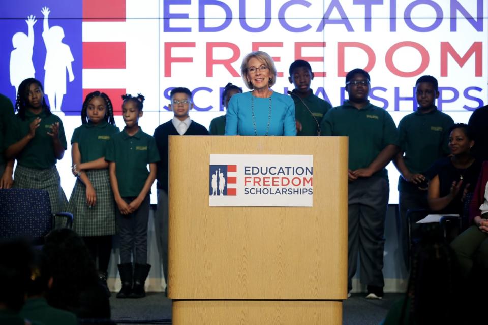 <div class="inline-image__caption"><p>Betsy DeVos stands in front of students from Digital Pioneers Academy during an event to discuss her proposal for Education Freedom Scholarships at the Education Department headquarters Feb. 28, 2019, in Washington, D.C. </p></div> <div class="inline-image__credit">Chip Somodevilla/Getty</div>