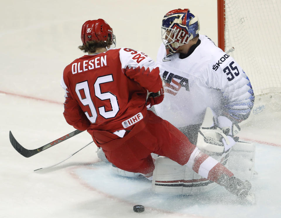 Denmark's Nick Olesen, left, tries to score past goaltender Cory Schneider of the US, right, during the Ice Hockey World Championships group A match between Denmark and the United States at the Steel Arena in Kosice, Slovakia, Saturday, May 18, 2019. (AP Photo/Petr David Josek)