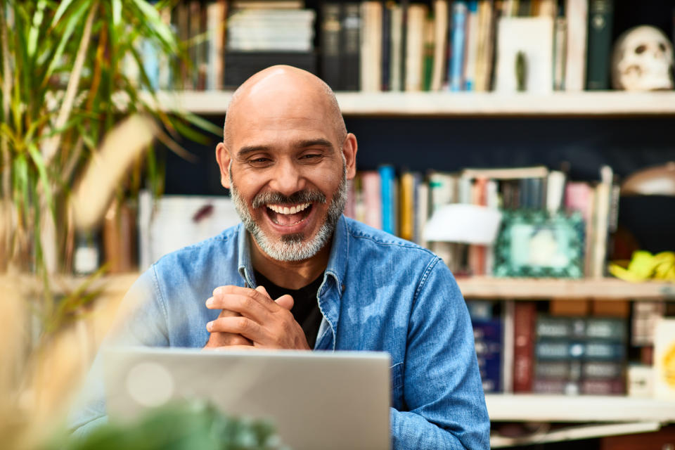 Man smiling at laptop screen during a video call, giving an impression of a pleasant conversation