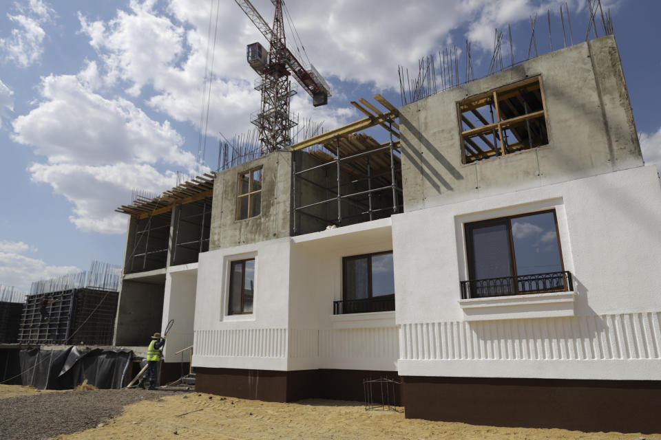 FILE - Workers build an apartment building for residents of Mariupol affected by hostilities, in Mariupol, in territory under control of the government of the Donetsk People's Republic, in eastern Ukraine, Friday, July 1, 2022. (AP Photo/File)