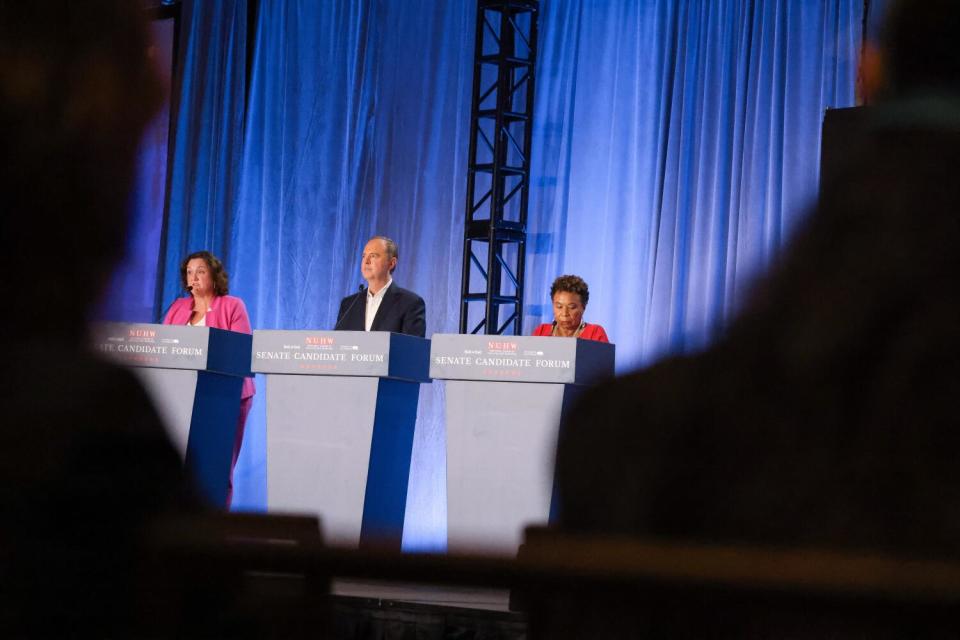 Rep. Katie Porter, Rep. Adam Schiff, and Rep. Barbara Lee, left to right participate in a debate on stage