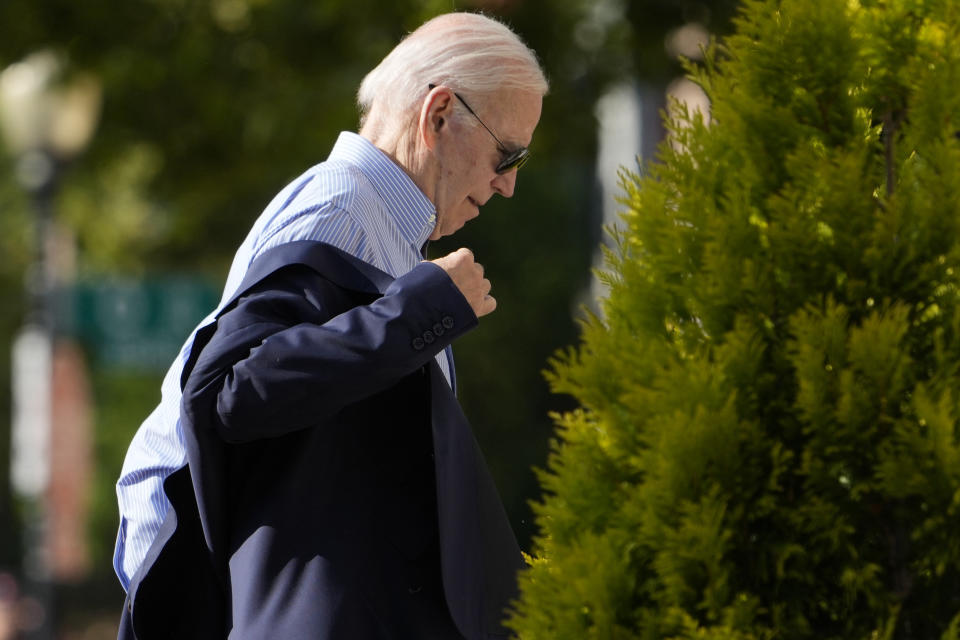 President Joe Biden puts his jacket on as he arrives at Holy Trinity Catholic Church in the Georgetown section of Washington, to attend Mass, Saturday, July 22, 2023. (AP Photo/Manuel Balce Ceneta)