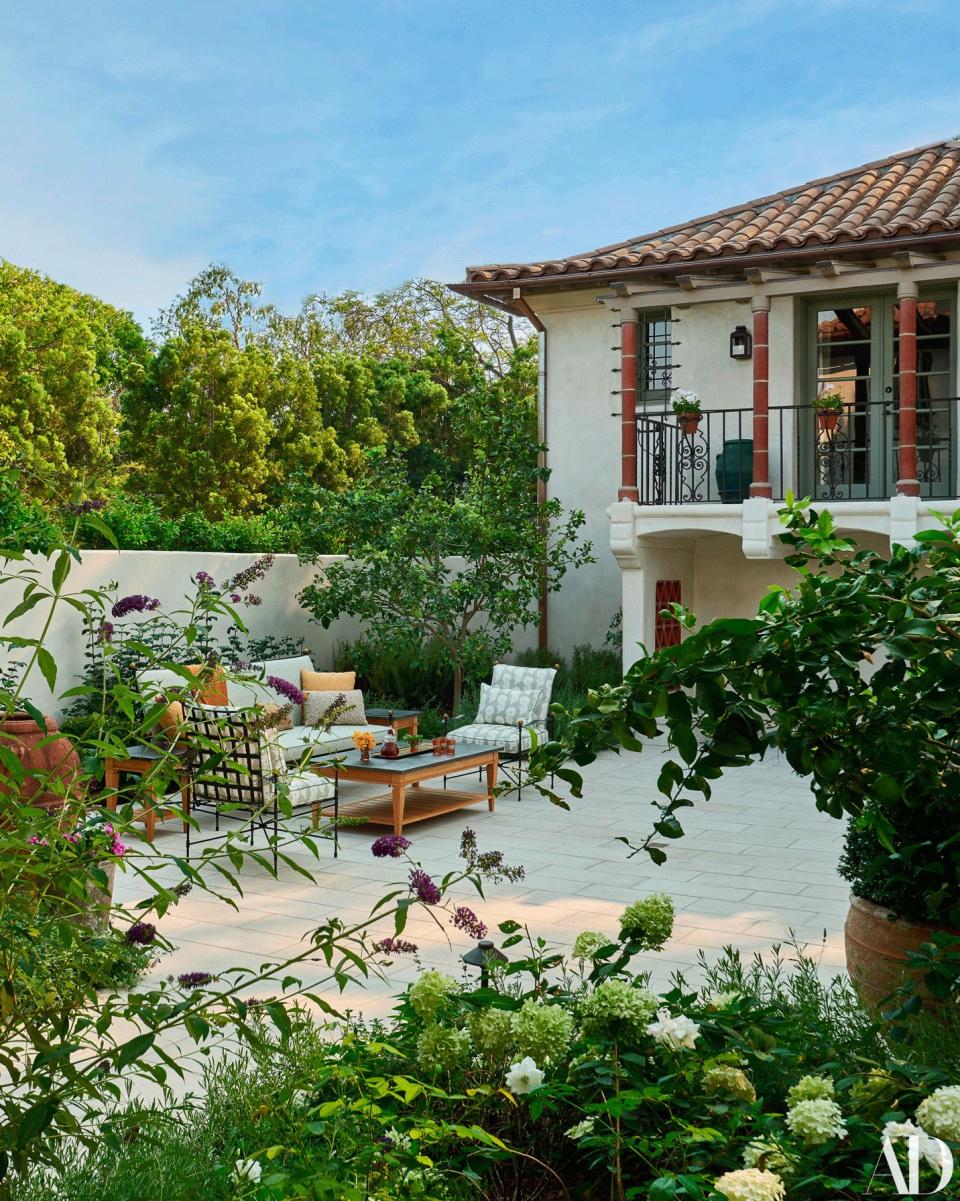 In the inner courtyard, a sofa and chairs by janus et Cie wear Jasper fabrics. table by Century Furniture.