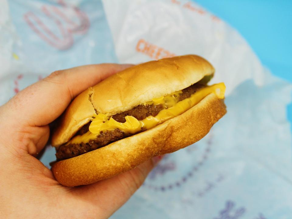 The author holds a mcdonalds double cheeseburger