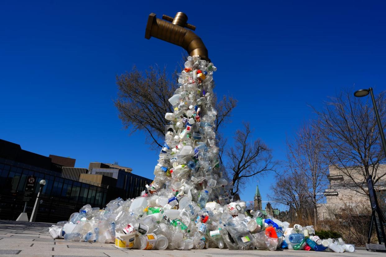 A sculpture titled 'Giant Plastic Tap' by Canadian artist Benjamin Von Wong stands outside the Fourth Session of the Intergovernmental Negotiating Committee on Plastics Pollution in Ottawa on Friday, April 22, 2024. (Sean Kilpatrick/The Canadian Press - image credit)