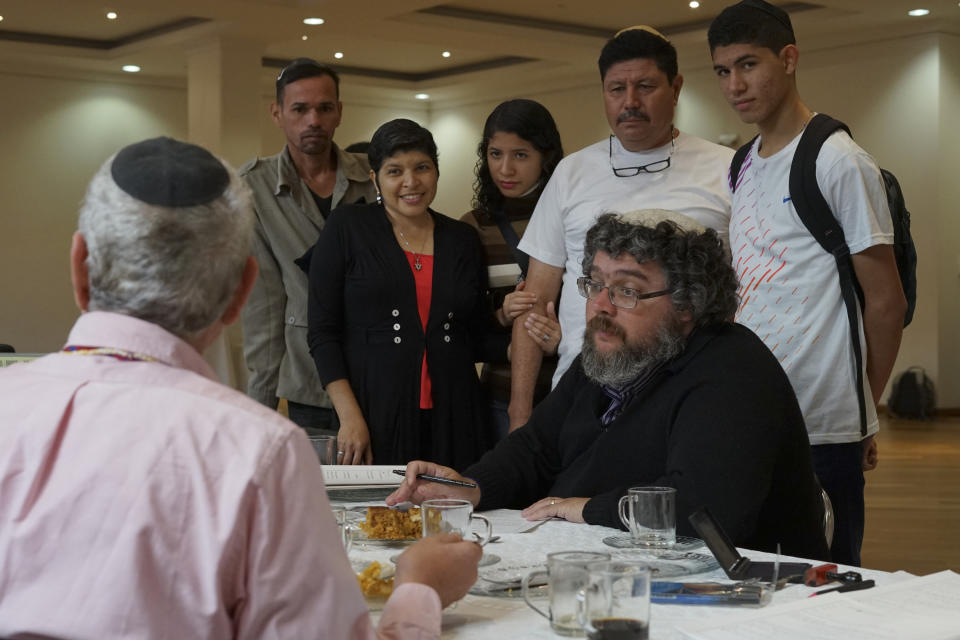 En esta imagen, tomada el 19 de marzo de 2017, un rabino cubre papeles en Bogotá, Colombia, para completar la conversión oficial de nueve venezolanos al judaísmo antes de su viaje a Israel. Según un funcionario israelí familiarizado con el caso, había pruebas que sugerían que algunos de los solicitantes se convirtieron al judaísmo para aprovecharse de los beneficios sociales israelíes, incluyendo el seguro médico. (AP Foto/Christine Armario)