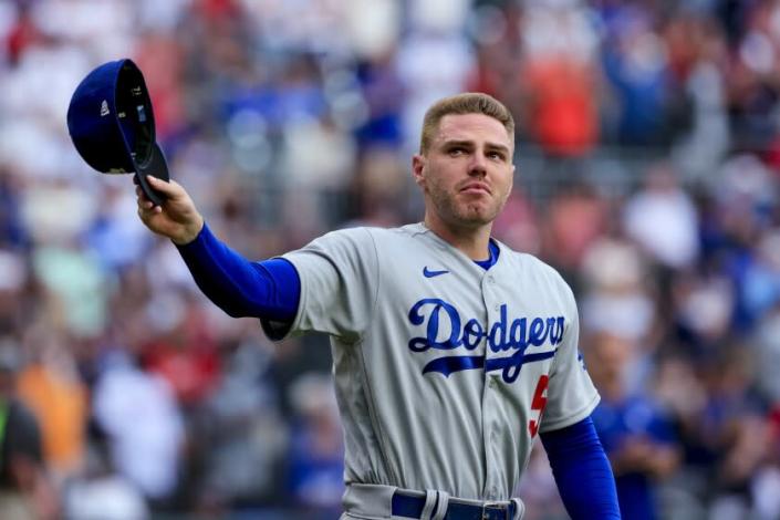 Los Angeles Dodgers first baseman Freddie Freeman walks to the field for the presentation of his World Series championship ring, before the team's baseball game against the Atlanta Braves on Friday, June 24, 2022 in Atlanta. (AP Photo/Butch Dill)