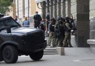 Members of a Ukrainian special forces unit are seen outside a building where an unidentified man reportedly threatens to blow up a bomb in a bank branch, in Kyiv