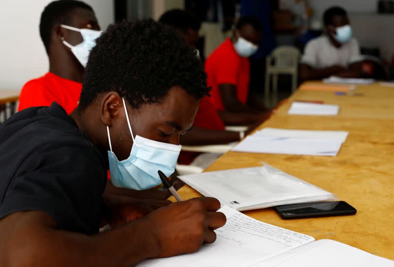 A group of Senegalese migrants who arrived on the island by boat receive Spanish lessons in Tito Martin's private garage in Las Palmas