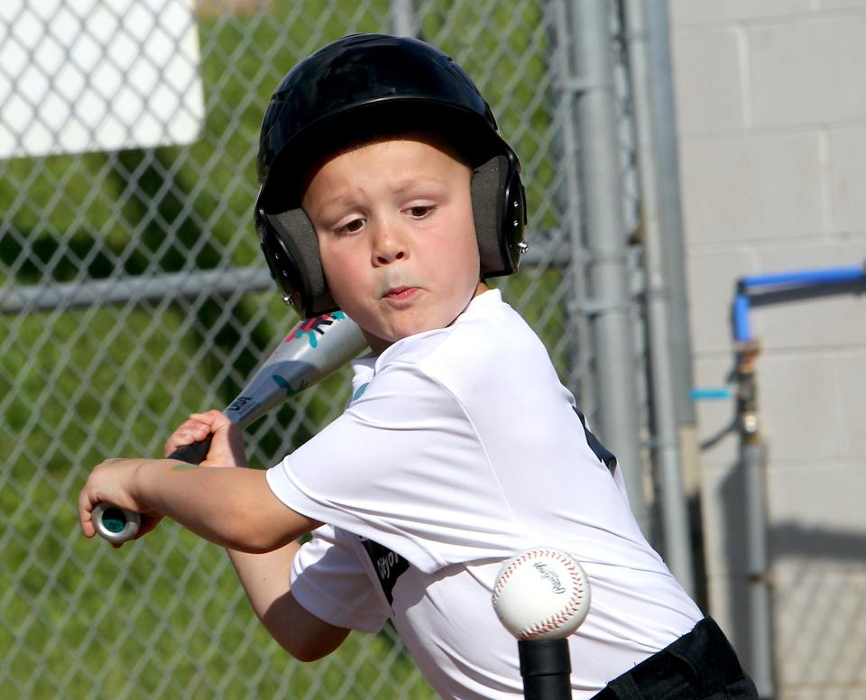 Wesson Gates concentrates on hitting the ball from a tee during a Tee Ball game at Wylie Park on Monday, May 13, 2024.