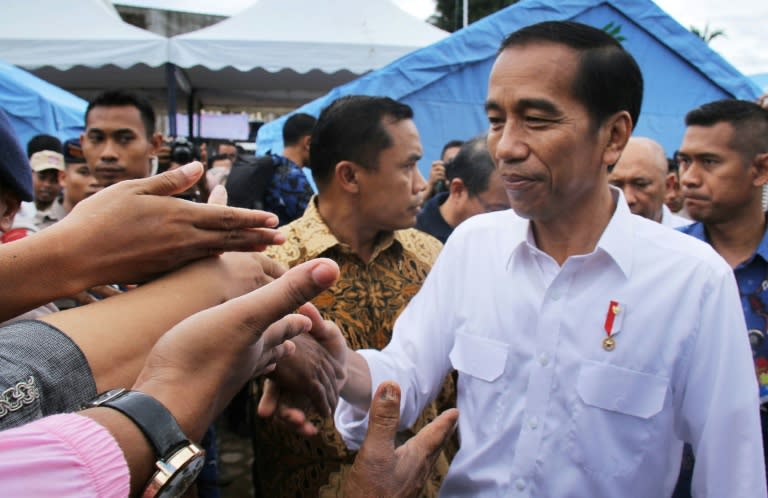 Indonesian President Joko Widodo shakes hands with quake survivors at a temporary shelter in Pidie Jaya, Aceh province