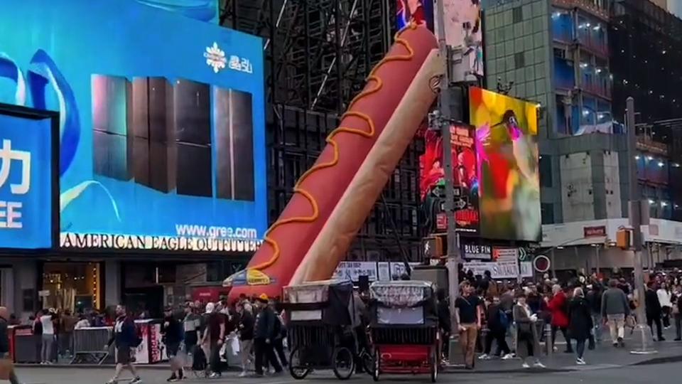 65-foot long hot dog art installation arrives in Times Square.