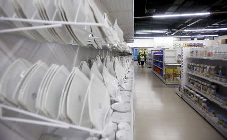 Employees walk along products shelves at a V+ super market in Hanoi, Vietnam June 29, 2015. REUTERS/Kham