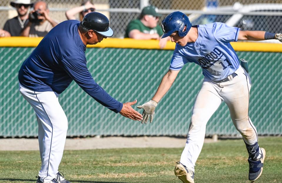Redwood Head Coach Dan Hydash, left, celebrates with Erik Rico after his home run against El Diamante in a Central Section Division I high school baseball quarterfinal playoff on Friday, May 19, 2023.