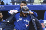 Toronto Blue Jays first baseman Vladimir Guerrero Jr., front, has the home run jacket put on him by Alek Manoah after his two-run home run against the Baltimore Orioles during the first inning of a baseball game Tuesday, Aug. 16, 2022, in Toronto. (Jon Blacker/The Canadian Press via AP)