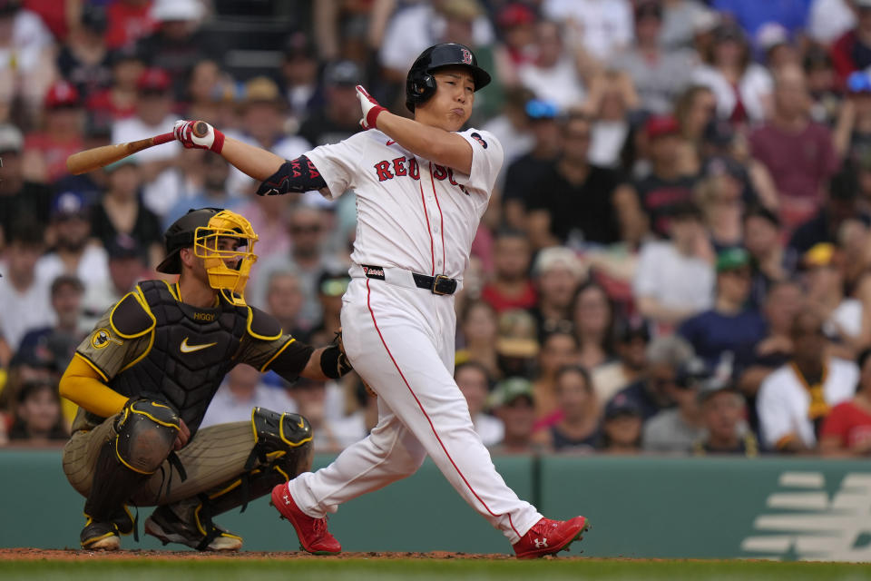 Boston Red Sox's Masataka Yoshida, right, hits a single in front of San Diego Padres catcher Kyle Higashioka, left, in the fourth inning of a baseball game, Sunday, June 30, 2024, in Boston. (AP Photo/Steven Senne)