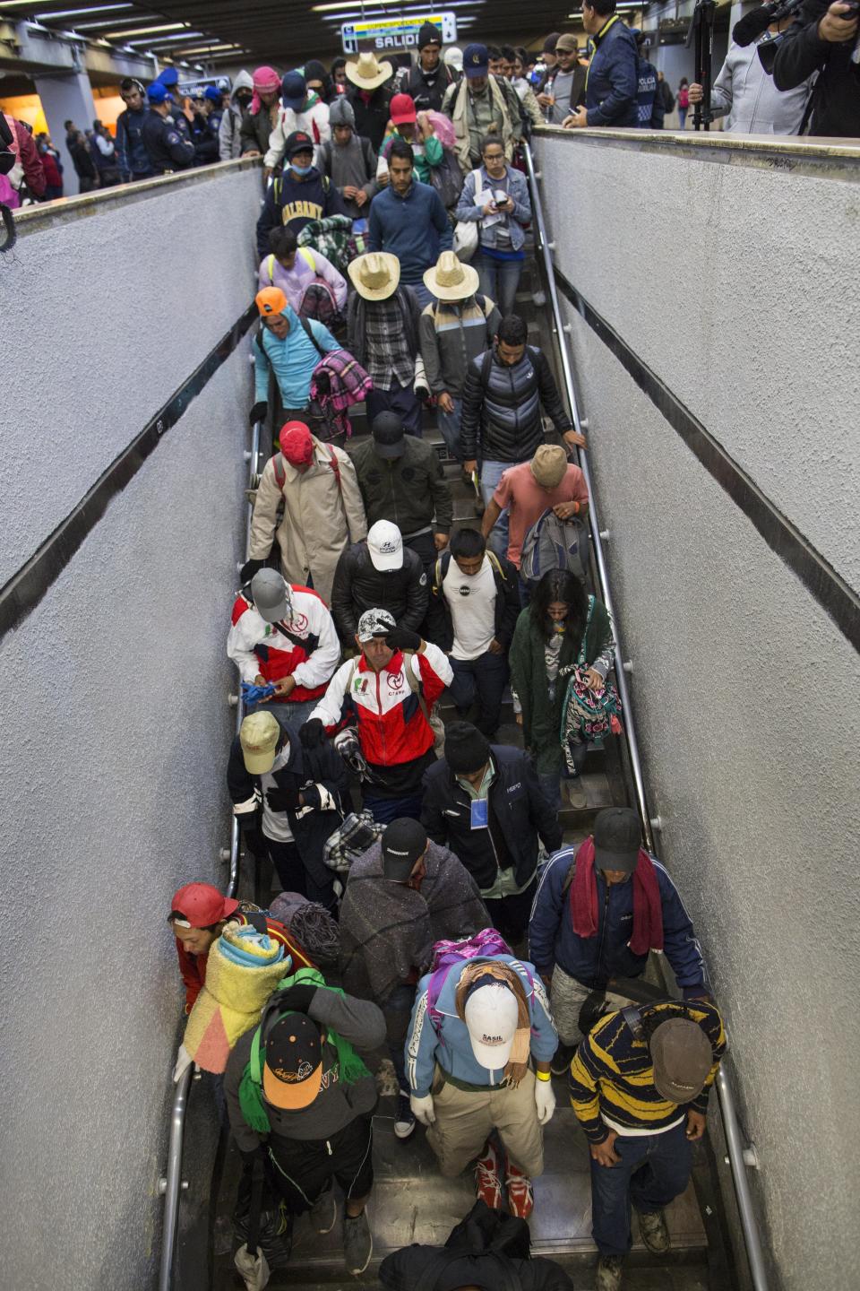 Central American migrants descend a flight of stairs at a subway after leaving the temporary shelter at the Jesus Martinez stadium, in Mexico City, Friday, Nov. 9, 2018. About 500 Central American migrants headed out of Mexico City on Friday to embark on the longest and most dangerous leg of their journey to the U.S. border, while thousands more were waiting one day more at the stadium. (AP Photo/Rodrigo Abd)