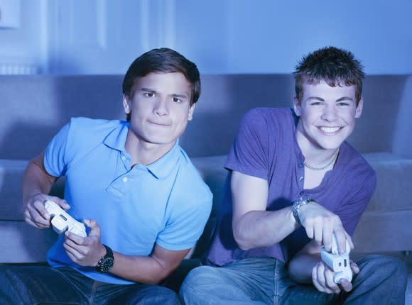 Two boys play a console video game.