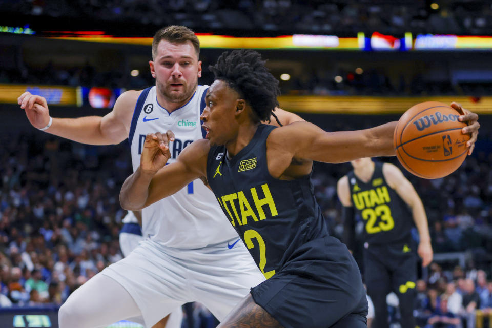 Utah Jazz guard Collin Sexton, front, drives to the basket against Dallas Mavericks guard Luka Doncic during the first half of an NBA basketball game Wednesday, Nov. 2, 2022, in Dallas. (AP Photo/Gareth Patterson)