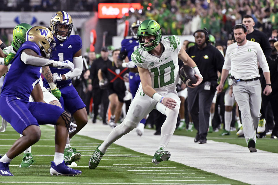 FILE - Oregon quarterback Bo Nix (10) looks to avoid a tackle by Washington during the second half of the Pac-12 championship NCAA college football game Friday, Dec. 1, 2023, in Las Vegas. Nix is a finalists for the Heisman Trophy. (AP Photo/David Becker, File)