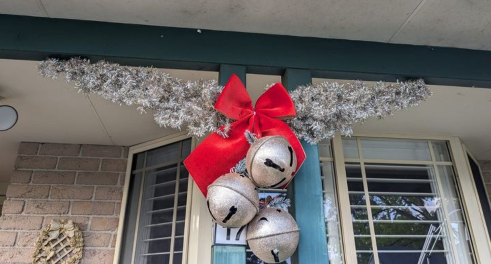 an outdoor Christmas garland made from two $5 Kmart tinsel trees and dollar store bells! 