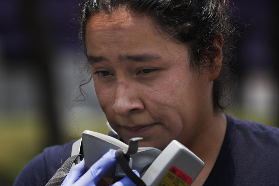 La paramédico Tania Quezada se somete a una descontaminación luego de visitar la casa de una persona sospechosa de estar infectada con el nuevo coronavirus, en su base Troya en Iztapalapa, un distrito de la Ciudad de México, el jueves 28 de mayo de 2020. (Foto AP/Marco Ugarte)