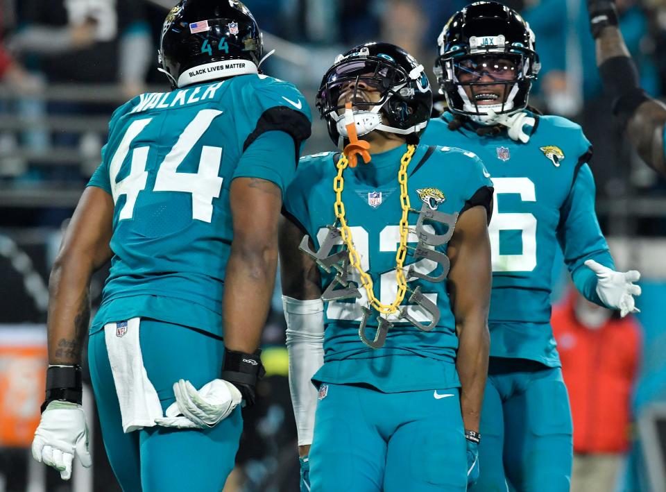 Jacksonville Jaguars cornerback Tyson Campbell (32) celebrates with teammates and a DUVAL chain from a fan in the stands after his late third-quarter interception. The Jacksonville Jaguars hosted the Tennessee Titans to decide the AFC South championship at TIAA Bank Field in Jacksonville, FL, Saturday, January 7, 2023. The Jaguars went into the half trailing 7 to 13 but came back to win with a final score of 20 to 16. [Bob Self/Florida Times-Union]