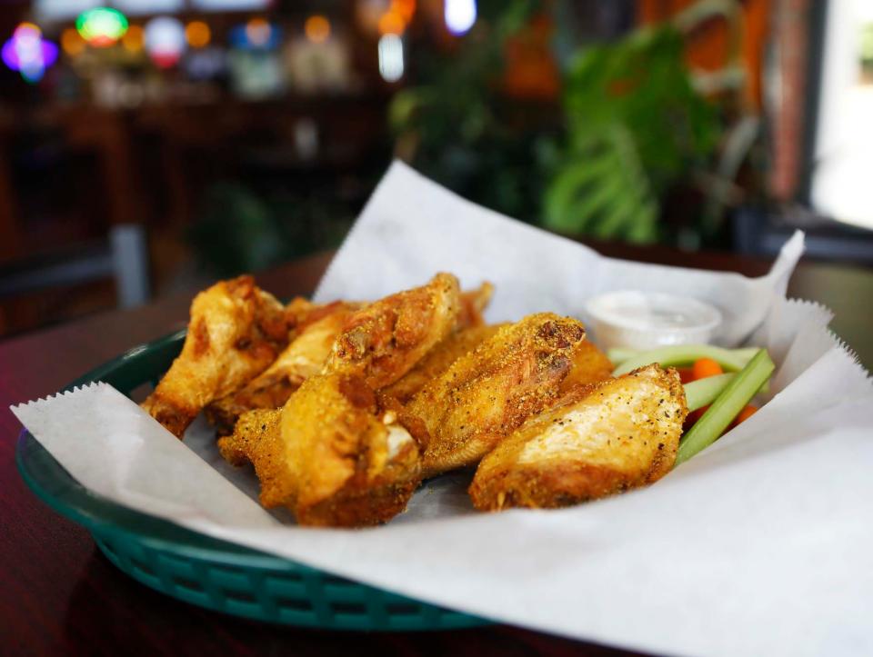 Mike Davis prepares lemon pepper seasoned wings on July 18, 2023, at Mike’s Hot Wings at 7730 Wolf River Blvd. in Germantown.