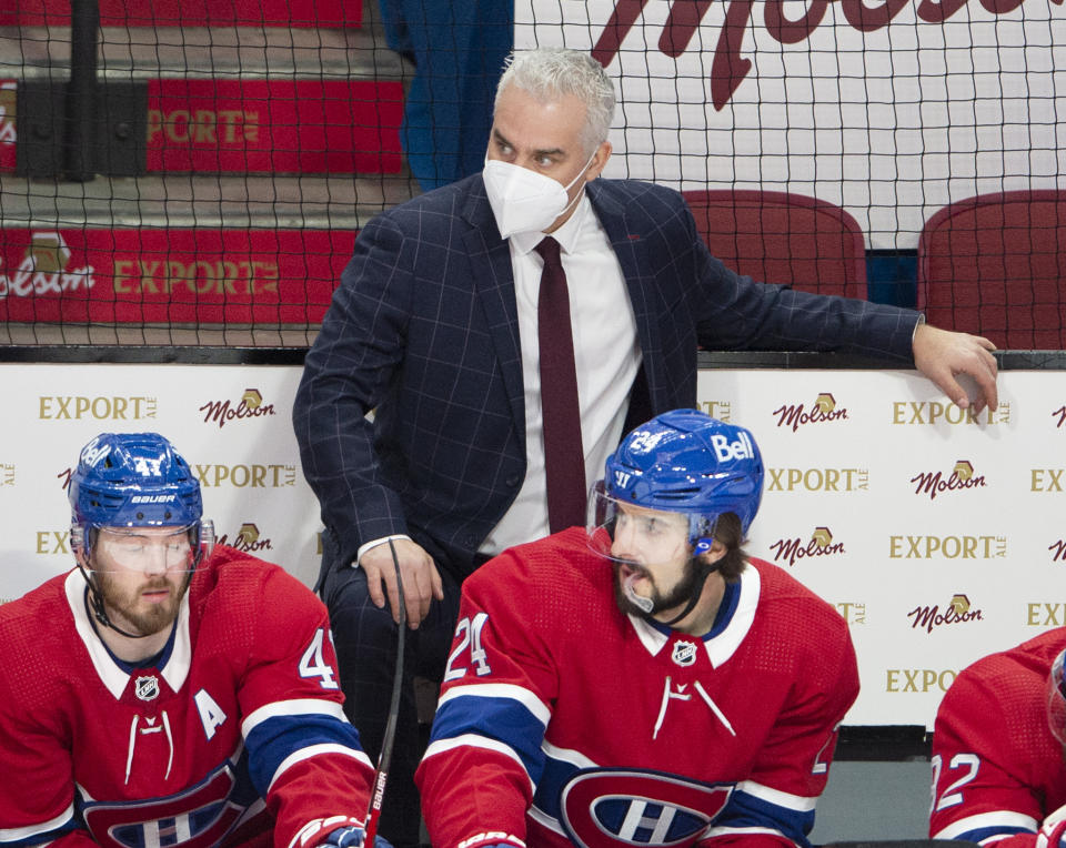 FILE - Montreal Canadiens coach Dominique Ducharme keeps an eye on the action, as do Paul Byron (41) and Phillip Danault (24) during the the team's NHL hockey game against the Ottawa Senators in Montreal, in this Tuesday, March 2, 2021, file photo. The four coaches left in the NHL playoffs have connections to each other, but they all took different paths to get to this point. (Ryan Remiorz/The Canadian Press via AP)