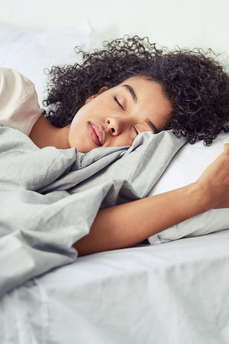 A woman lays in bed asleep