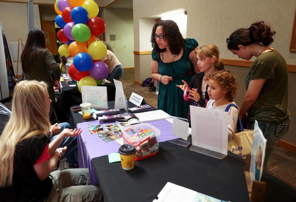 Grand Prairie resident Maurica Curry, center, talks to a vendor while attending the Texas Homeschool Expo at the Grapevine Convention Center with her three children on Friday, June 9, 2023, in Grapevine.