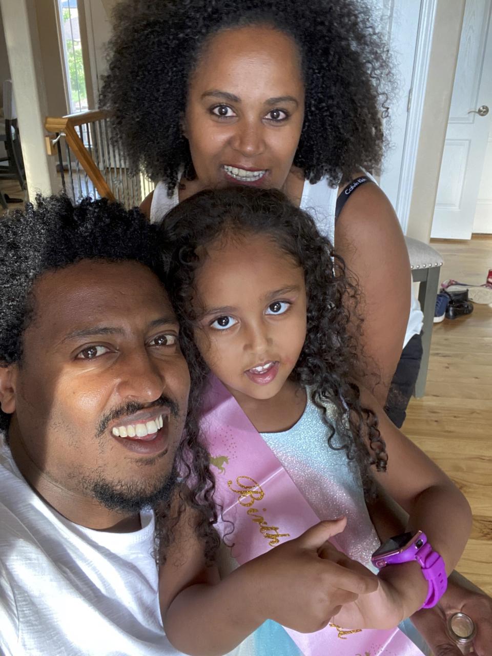 This undated family photo provided by The Dan Caplis Law Firm, LLC shows a photo of Wongel Estifanos, center, and her parents, Estifanos Dagne and Rahel Estifanos. The parents of Wongel, a 6-year-old Colorado girl who fell 110 feet (34 meters) to her death on a theme park ride after not being buckled in filed a lawsuit against the park Wednesday, Oct. 20, 2021, alleging it recklessly caused her death by failing to train the ride's operators despite previous problems with its seat belts. State investigators concluded that Wongel Estifanos' death on the Haunted Mine Drop ride at Glenwood Caverns Adventure Park on Sept. 5 was the result of multiple operator errors. (The Dan Caplis Law Firm, LLC via AP)