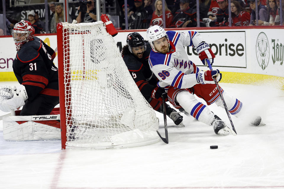 New York Rangers' Jack Roslovic (96) controls the puck in front of Carolina Hurricanes' Jalen Chatfield (5) behind Hurricanes goaltender Frederik Andersen (31) during the first period in Game 4 of an NHL hockey Stanley Cup second-round playoff series in Raleigh, N.C., Saturday, May 11, 2024. (AP Photo/Karl B DeBlaker)