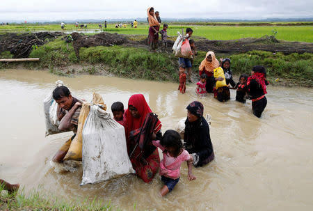 A group of Rohingya refugee people cross a canal as they walk towards Bangladesh after crossing the Bangladesh-Myanmar border in Teknaf, Bangladesh, September 1, 2017. REUTERS/Mohammad Ponir Hossain