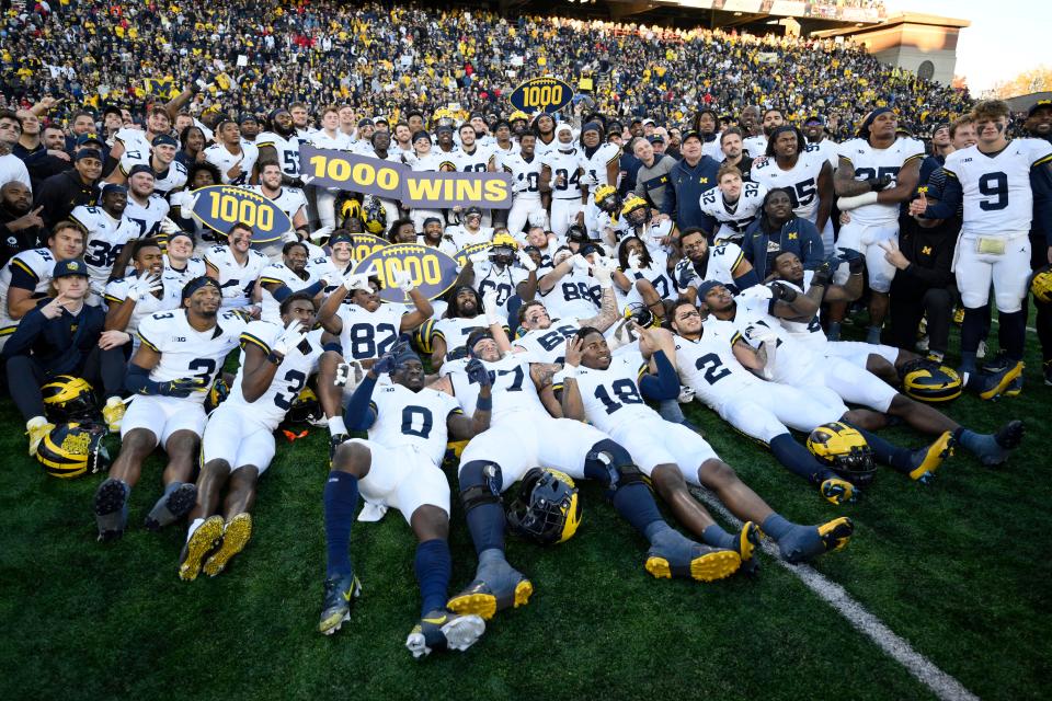 Michigan poses for photographers after a 31-24 win over Maryland that earned the Wolverines their 1,000 win in school history, Saturday, Nov. 18, 2023, in College Park, Md.