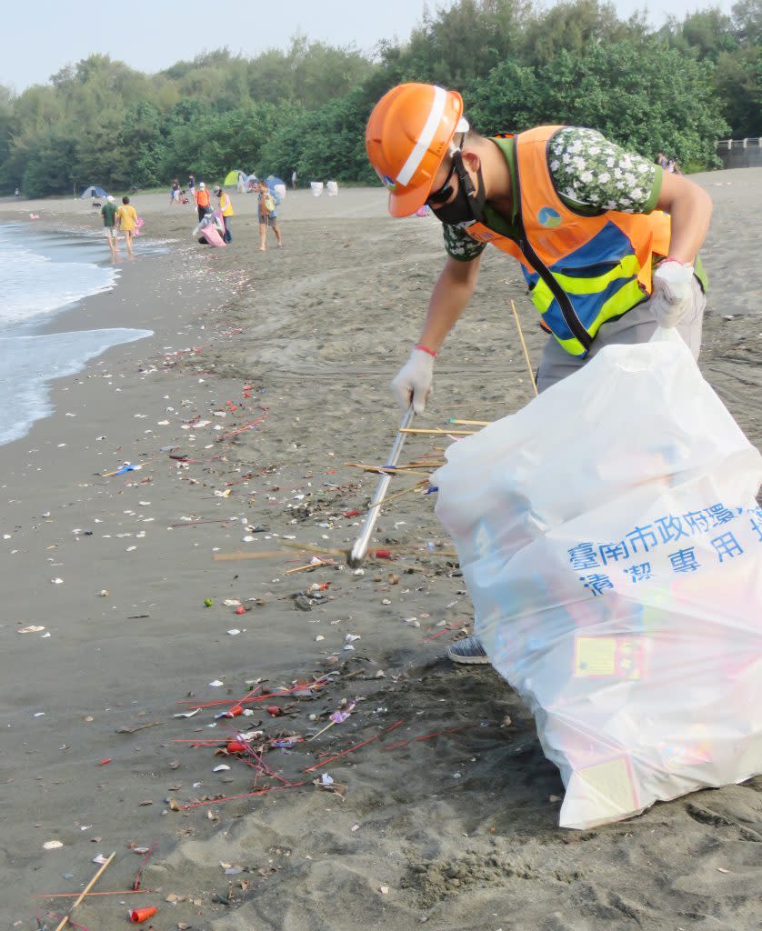 環保局人員清除擱淺沙灘上的炮竹垃圾。（記者陳治交攝）