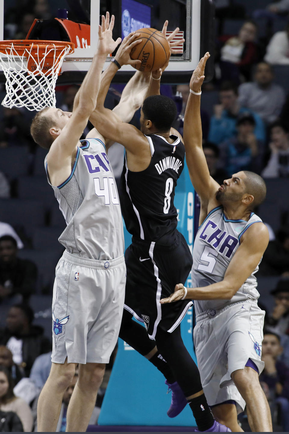 Charlotte Hornets' Cody Zeller (40) and Nicolas Batum (5) team up to try and stop Brooklyn Nets' Spencer Dinwiddie (8) on his way to the basket during the second half of an NBA basketball game in Charlotte, N.C., Friday, Dec. 6, 2019. The Nets won 111-104. (AP Photo/Bob Leverone)