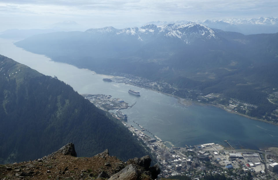 Cruise ships near downtown Juneau, Alaska, in May 2019, in this view from from Mount Juneau. The Canadian government has extended a ban on cruise ships through February 2022, which is expected to block ships from visiting Alaska this year. (AP Photo/Becky Bohrer)