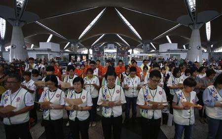 Volunteer rescue workers and religious organizations pray during multi-religion mass prayers for the passengers of Malaysian Airlines flight MH370, at the Kuala Lumpur International Airport in Sepang March 9, 2014. REUTERS/Edgar Su